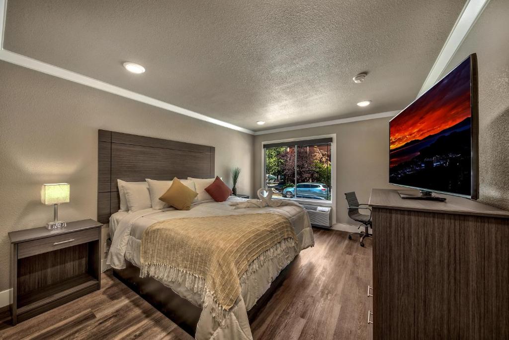 a bedroom with a bed and a flat screen tv at The Elet Hotel in South Lake Tahoe