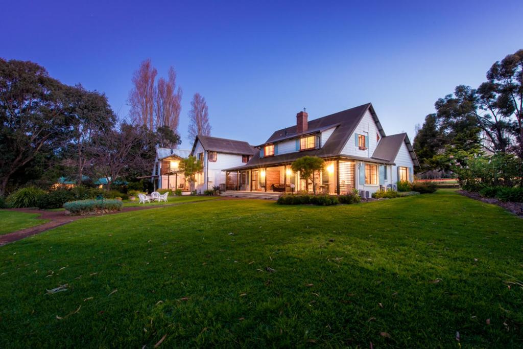 a large white house with a large yard at night at Sienna Lodge in Yallingup