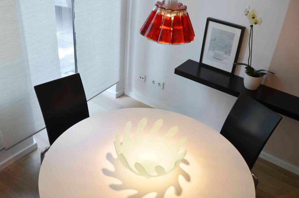 una sala da pranzo con tavolo bianco e lampada di Puro-Design-Apartment Deluxe - very central a Monaco