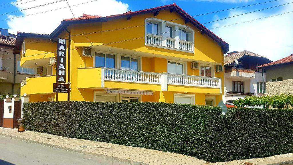 a yellow building with a fence in front of it at Къща Мариана in Gotse Delchev