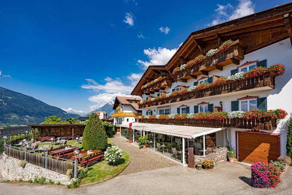 a building with flowerpots on the balconies of it at Hotel Stefanie in Tirolo