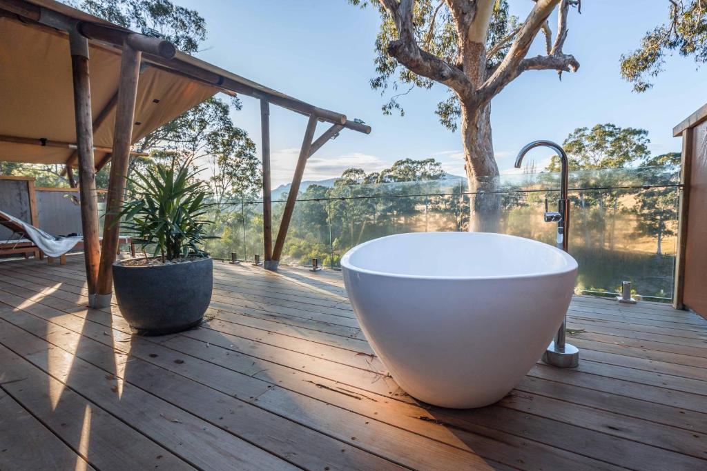 a bath tub on a deck with a view of the water at Currajong Retreat in Burragate