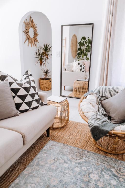 a living room with a couch and a mirror at 27 Degrees Kalbarri in Kalbarri