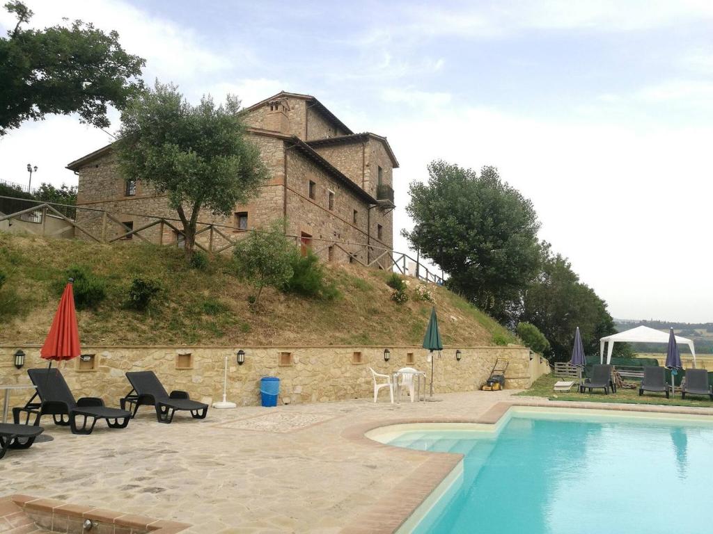 un edificio en una colina con una piscina delante en Camera Matrimonialedoppia Con Balcone Vista Piscina, en Monte Molino