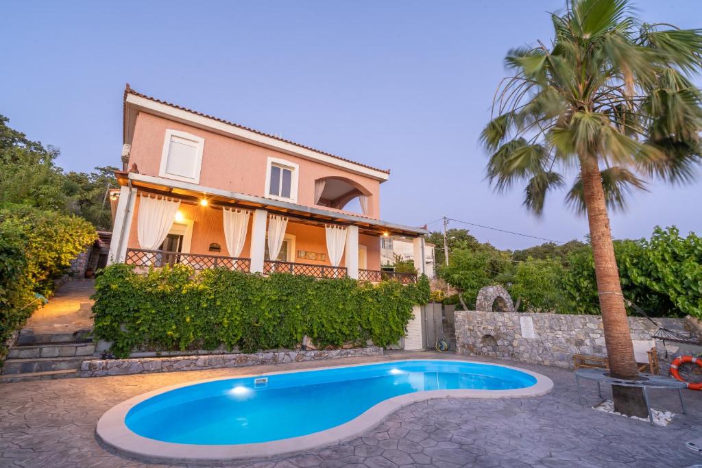 a villa with a swimming pool in front of a house at Dryades Villa in Arménoi