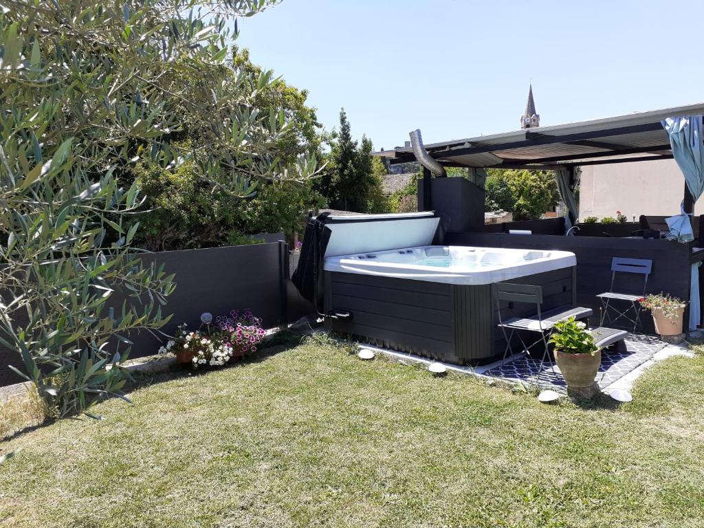 a backyard with a hot tub in a yard at Chambres d&#39;hôtes &amp; jacuzzi - A l&#39;ombre des amandiers in Saint-Martin-dʼArdèche