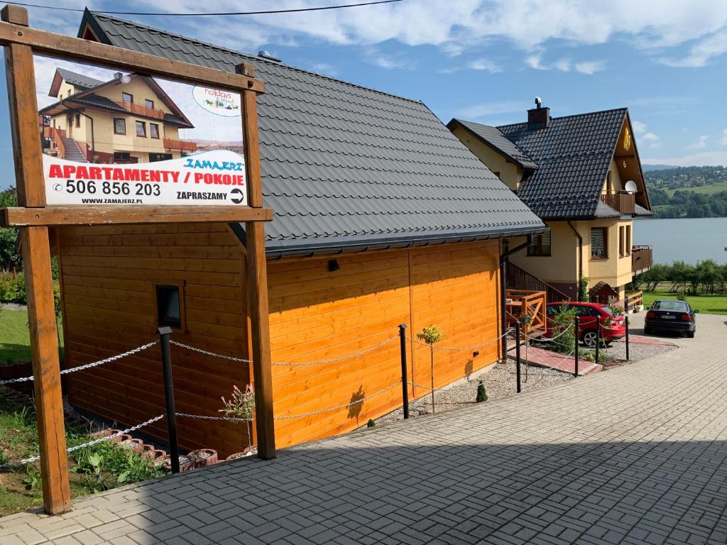 a building with a sign in front of it at Zamajerz Nad Zalewem in Niedzica Zamek