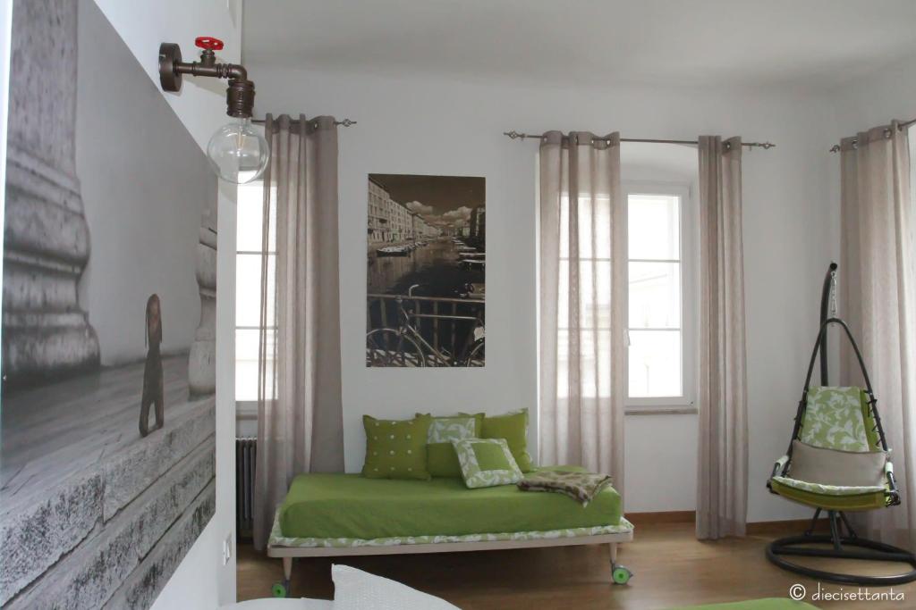 un soggiorno con divano verde e finestra di Casa Griot a Trieste