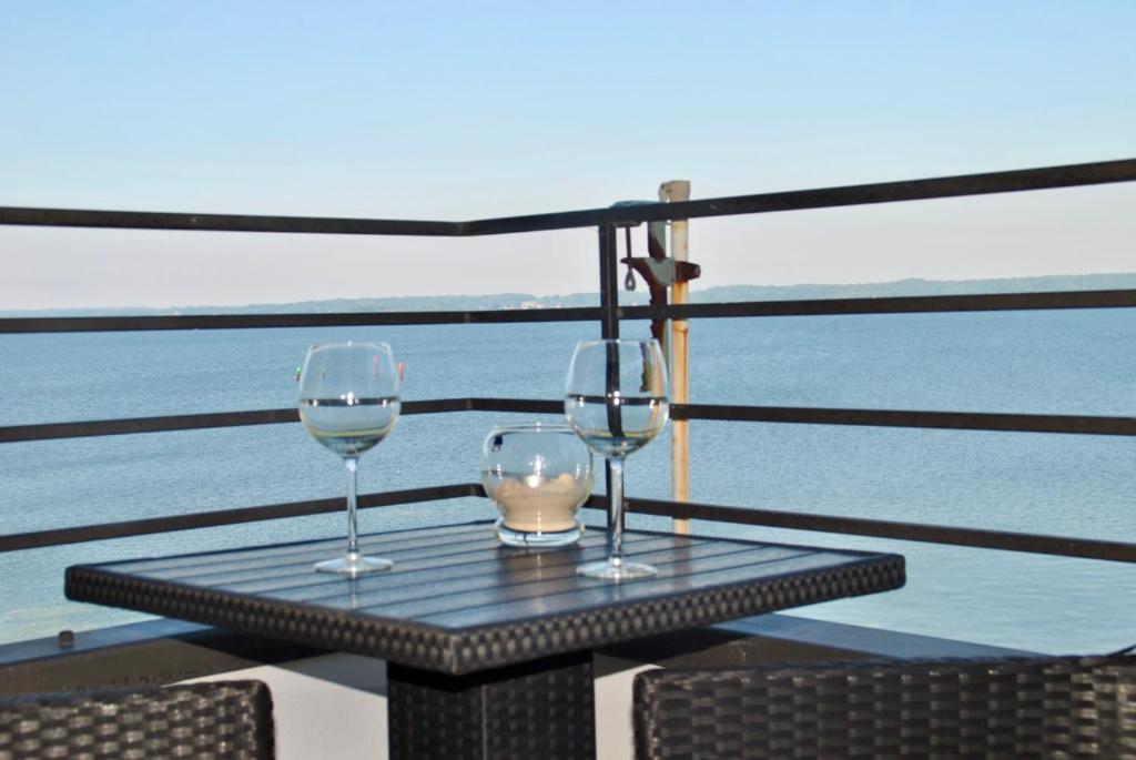 zwei Weingläser auf einem Tisch auf einem Balkon in der Unterkunft Mare in Glücksburg