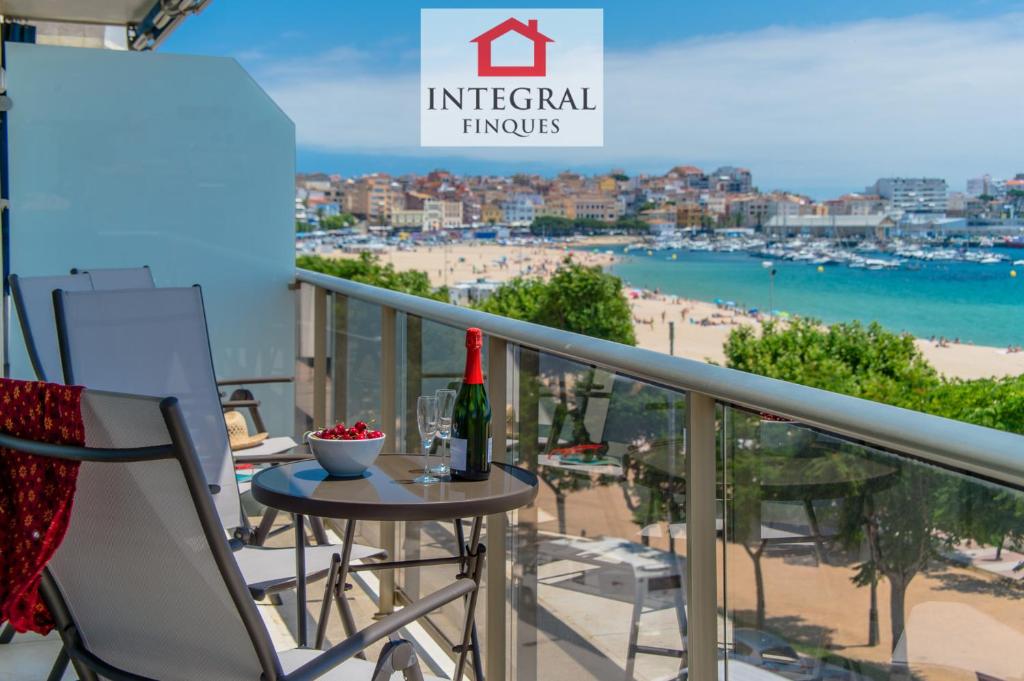 a balcony with a table and chairs and a view of the beach at La Vela Apartment in Palamós