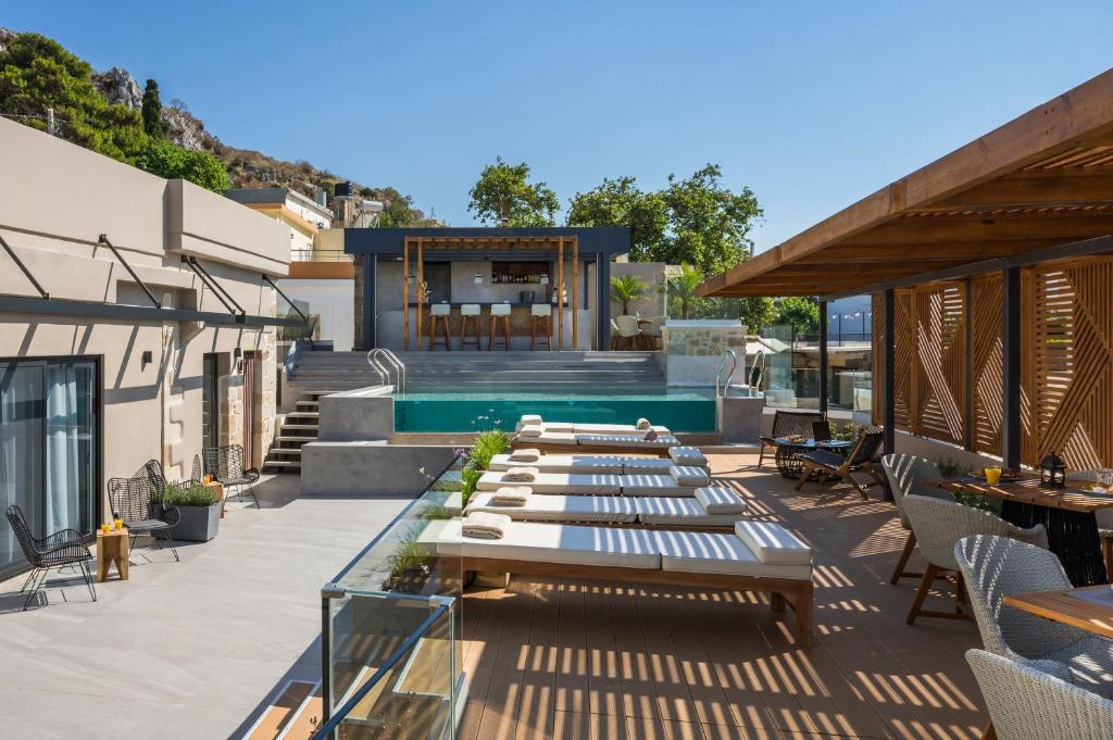 a patio with tables and chairs and a swimming pool at Casa D'Irene Deluxe Hotel in Falasarna