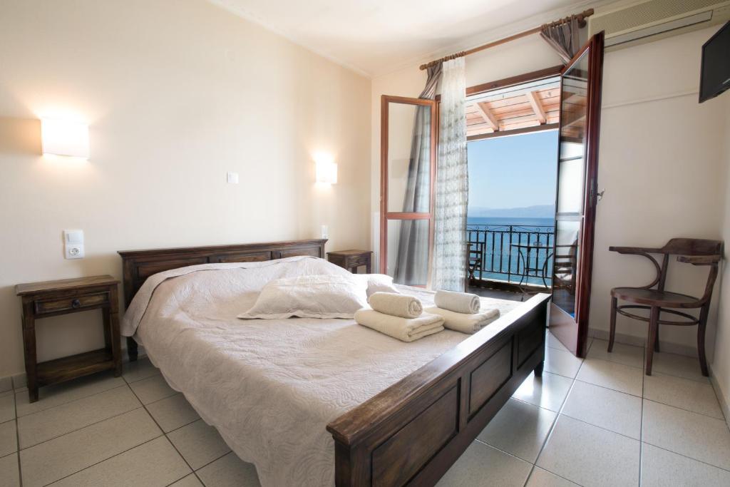 a bedroom with a bed with a view of the ocean at SAGA Pension in Gythio