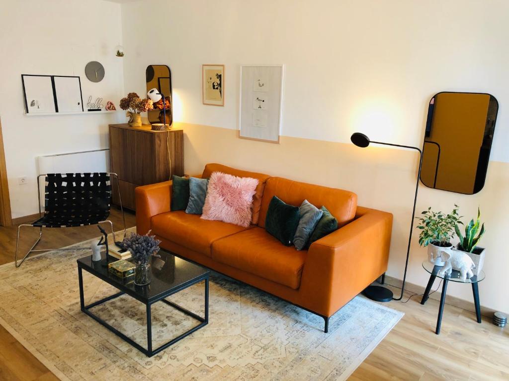 sala de estar con sofá naranja y mesa en Apartments Porec, en Poreč