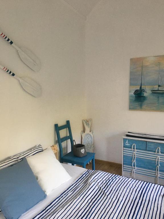 1 dormitorio con 1 cama, 1 silla y 1 pintura en Dom pod Białym Pagajem en Pisz