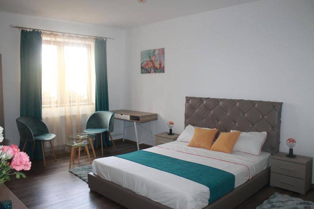 a bedroom with a bed with a desk and chairs at STUDIO TURQUOISE Victoria in Bucharest
