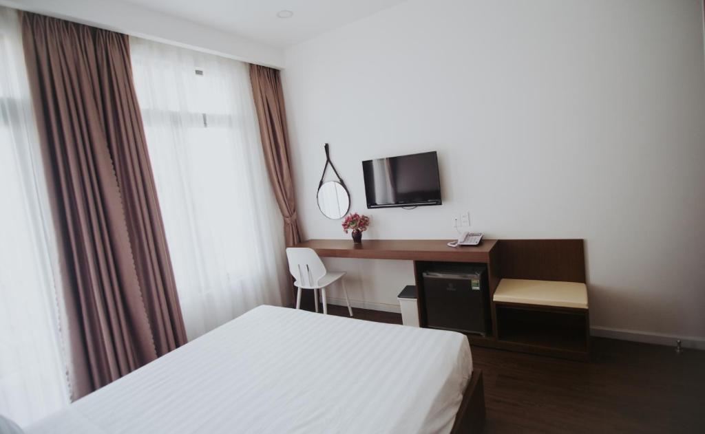 a hotel room with a bed and a desk at Marina Hotel Phú Yên in Tuy Hoa