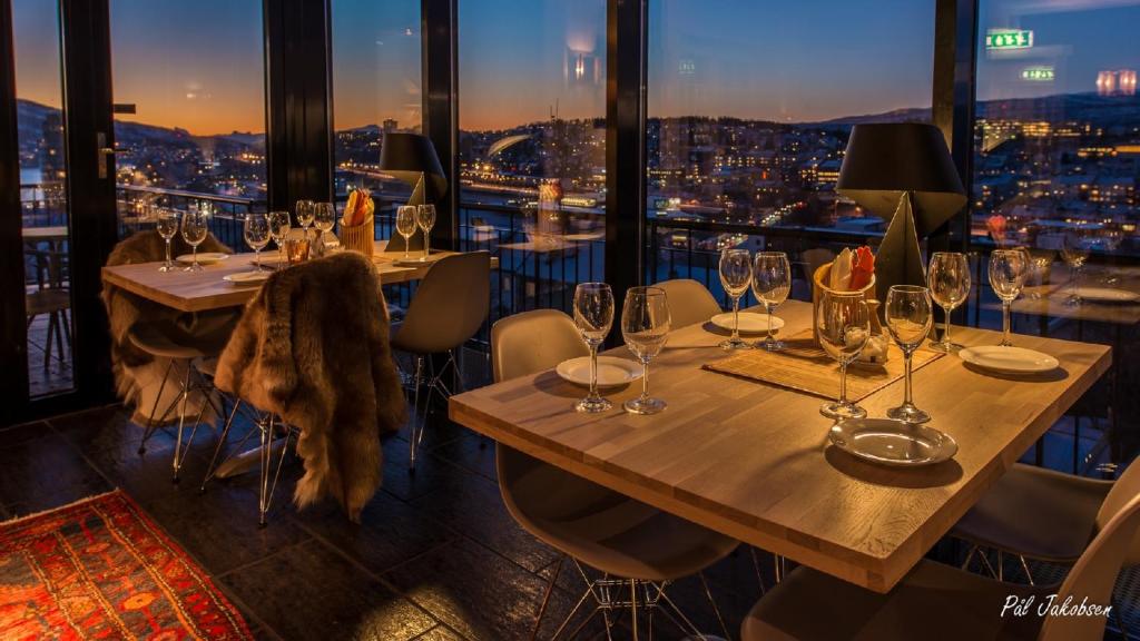 a restaurant with tables and chairs with a view at Breidablikk Guesthouse in Narvik