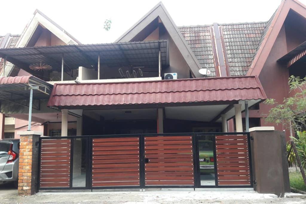 una casa con una puerta de madera y un edificio en D Santai Homestay, en Kuala Terengganu