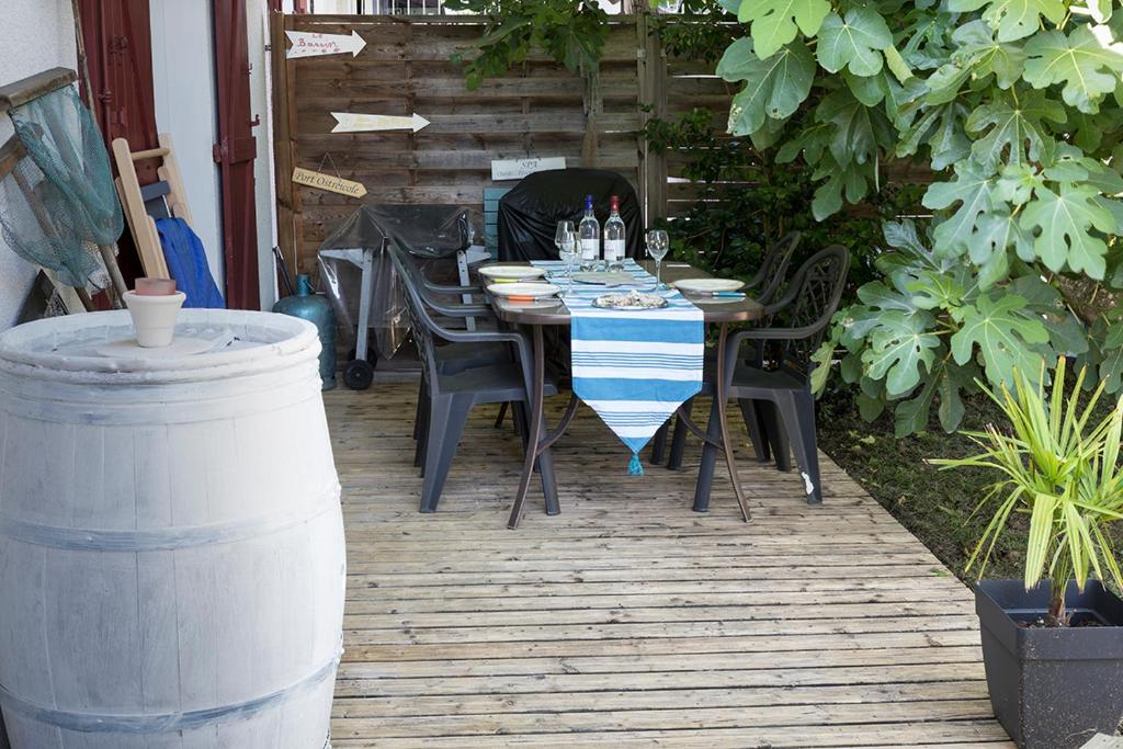 uma mesa e cadeiras sentadas num pátio em maisonpetitgasbiganos em Biganos