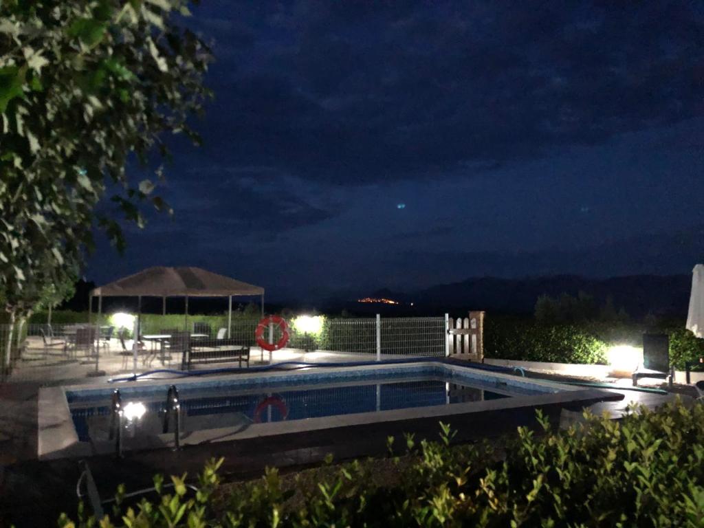 una piscina por la noche con cenador en Ruralracons, en Cretas