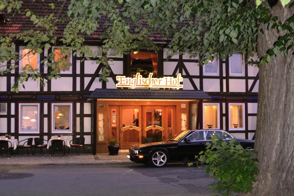 een auto geparkeerd voor een hotel naast een gebouw bij Hotel Englischer Hof in Herzberg am Harz