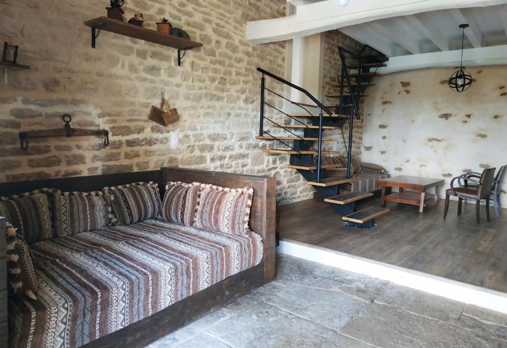 uma sala de estar com um sofá e uma escada em espiral em Terraloft, Calme, Authenticité et Vue sur la vallée em Sombernon