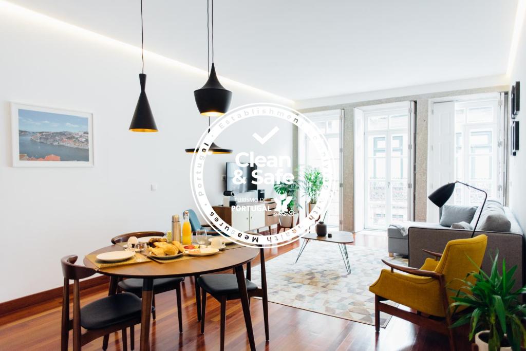 uma sala de estar com uma mesa e um relógio na parede em Myo Design House no Porto