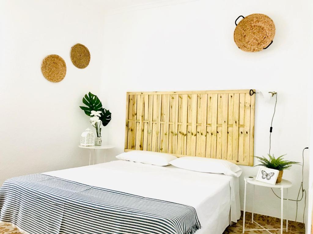 a bedroom with a bed with a wooden headboard at Casita Marinera in Peñíscola