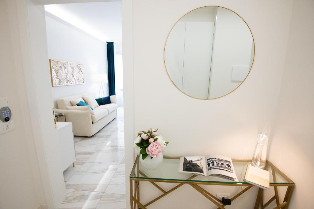 a living room with a mirror and a table with books at Sweet Home Suites - Verona in Verona