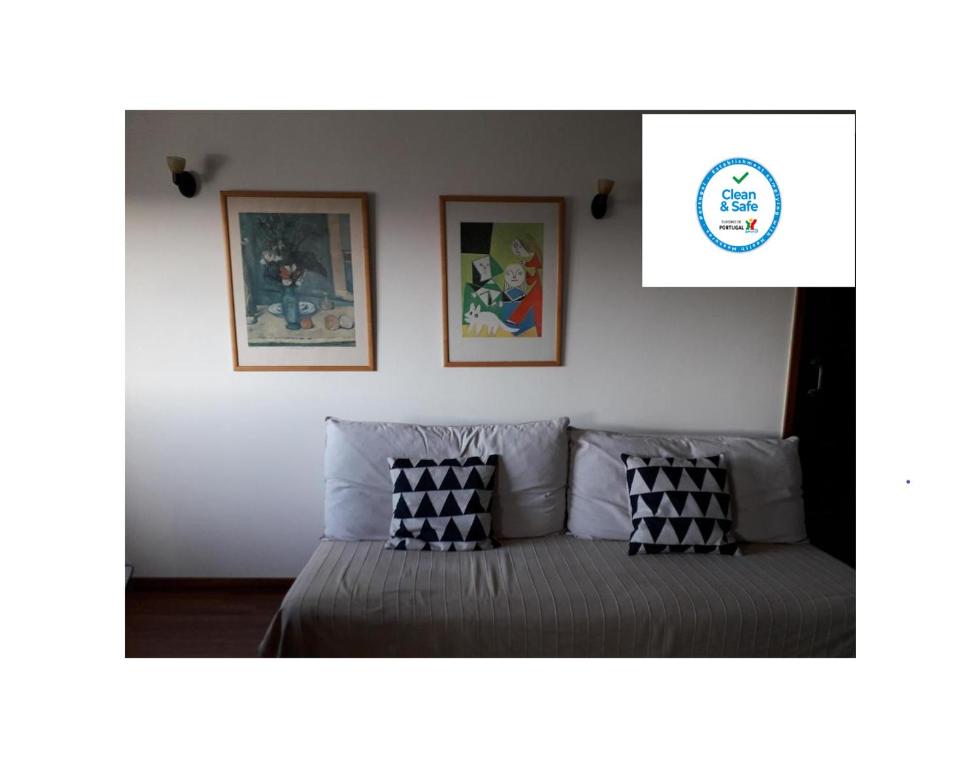 a bedroom with two beds and two pictures on the wall at Apartamento Fonte Luz in Matosinhos