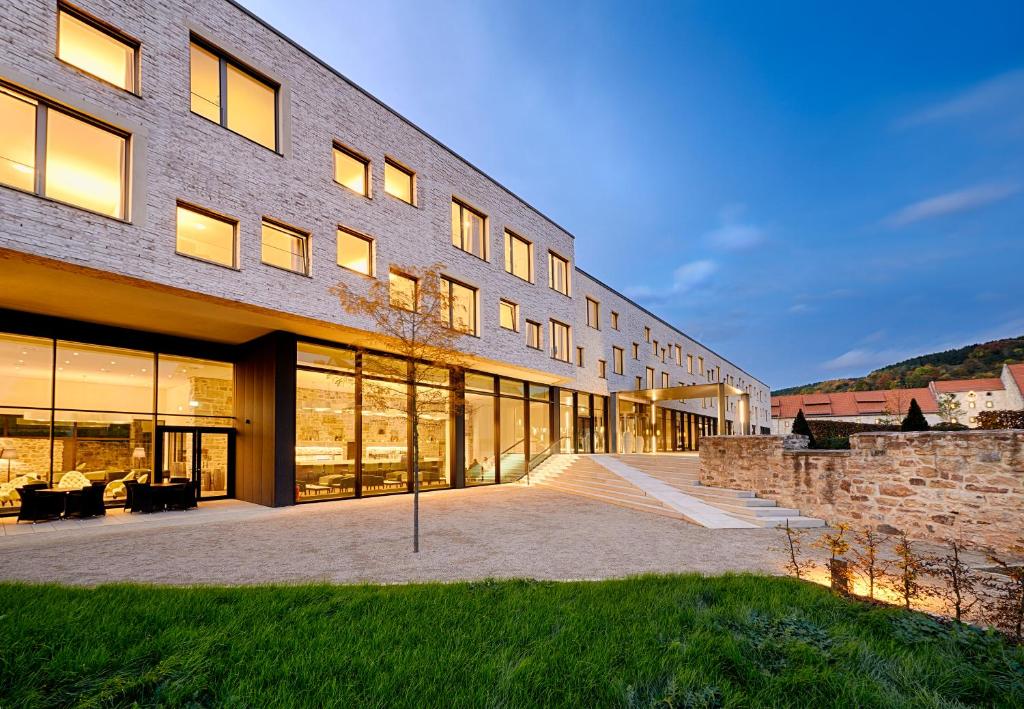 a large brick building with windows and a lawn at Hotel Kloster Haydau in Morschen