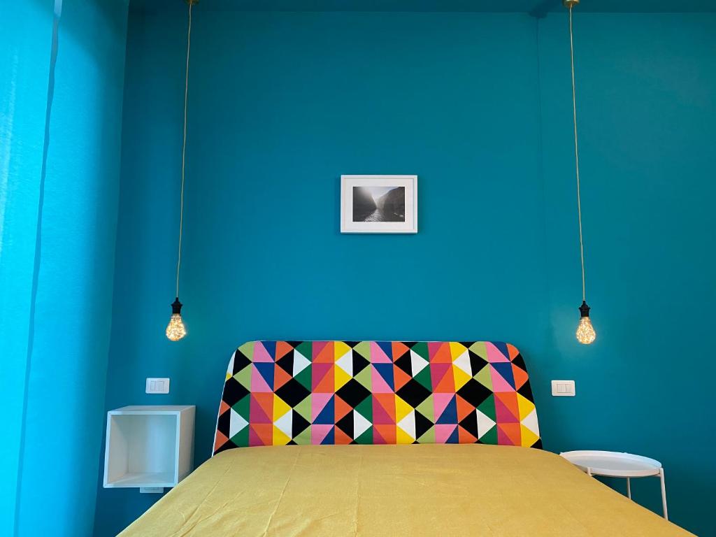 Habitación azul con cama con silla colorida en Kaleido, en Florencia