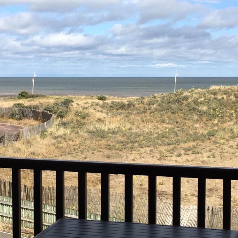 d'un balcon avec vue sur la plage. dans l'établissement Face à la mer à Cabourg, à Cabourg