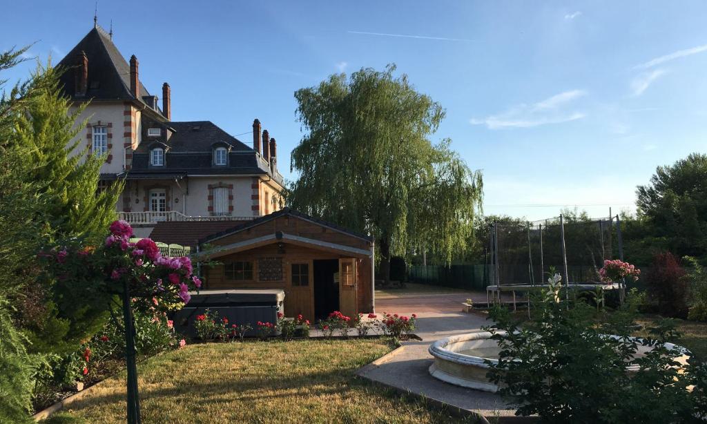 una casa con una fuente frente a un patio en Gite Logis des Fontaines, en Raon-lʼÉtape