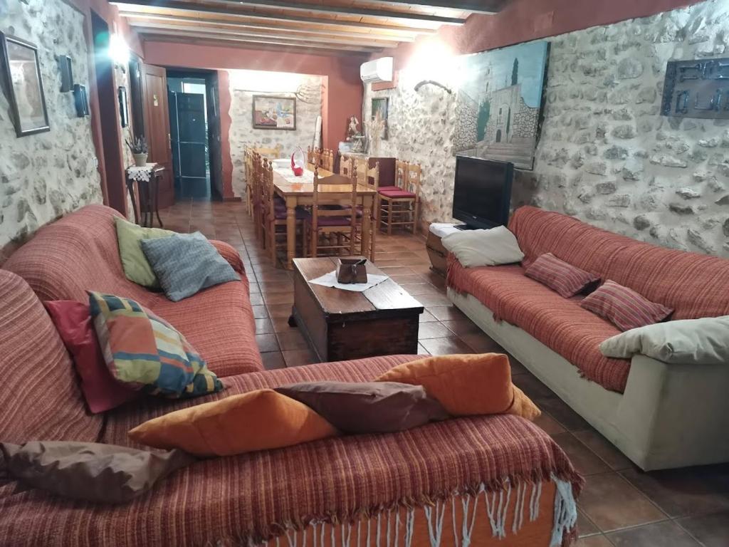 een woonkamer met 2 banken en een tafel bij Casa Rural Calaceit in Sant Mateu