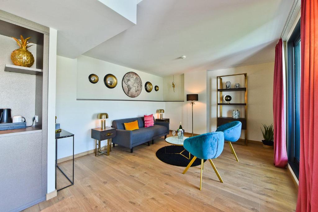 a living room with a blue couch and a table at Hôtel La Villa Port d'Antibes & Spa in Antibes