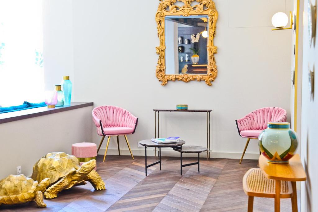 a room with pink chairs and a mirror at Hôtel La Villa Port d'Antibes & Spa in Antibes
