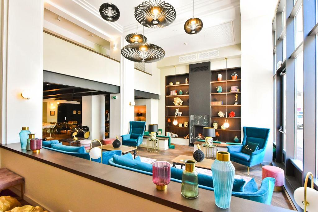 een grote lobby met blauwe stoelen en tafels bij Hôtel La Villa Port d'Antibes & Spa in Antibes