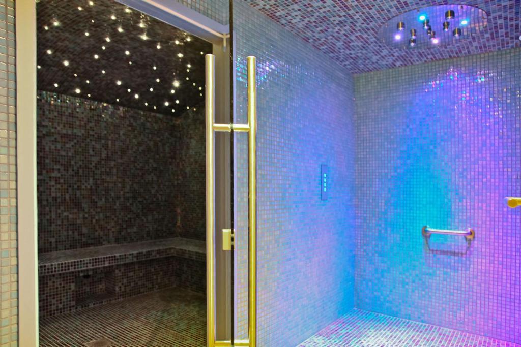 a bathroom with a walk in shower with purple tiles at Hôtel La Villa Port d'Antibes & Spa in Antibes