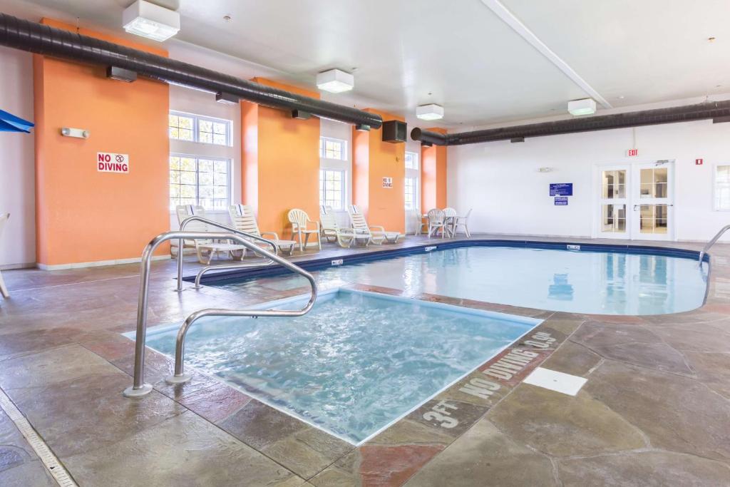 een zwembad in een gebouw met tafels en stoelen bij Motel 6-Huron, OH - Sandusky in Huron