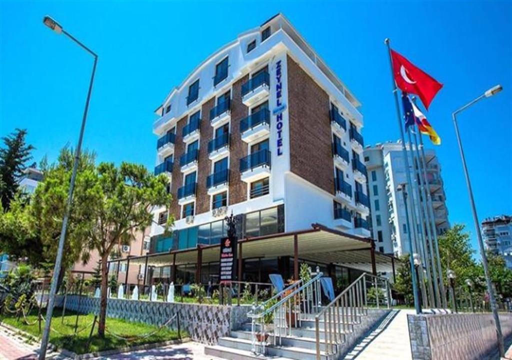 a hotel building with a flag and a flag at Zeynel Hotel in Antalya