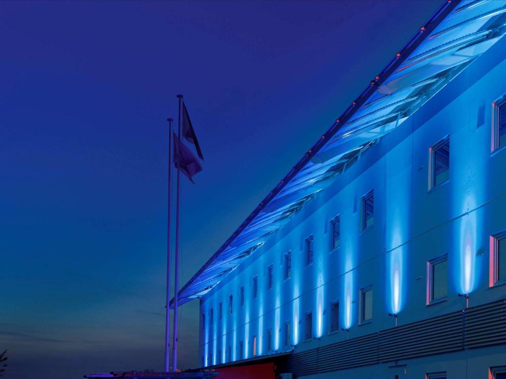 um edifício azul com uma bandeira em cima em ibis budget Saint-Brieuc Yffiniac em Yffiniac