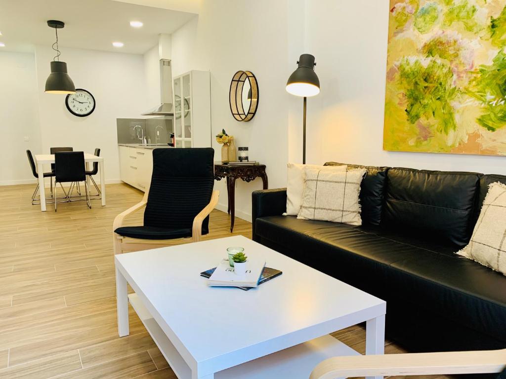 - un salon avec un canapé et une table dans l'établissement Homely Málaga Luxury Atarazanas, à Malaga