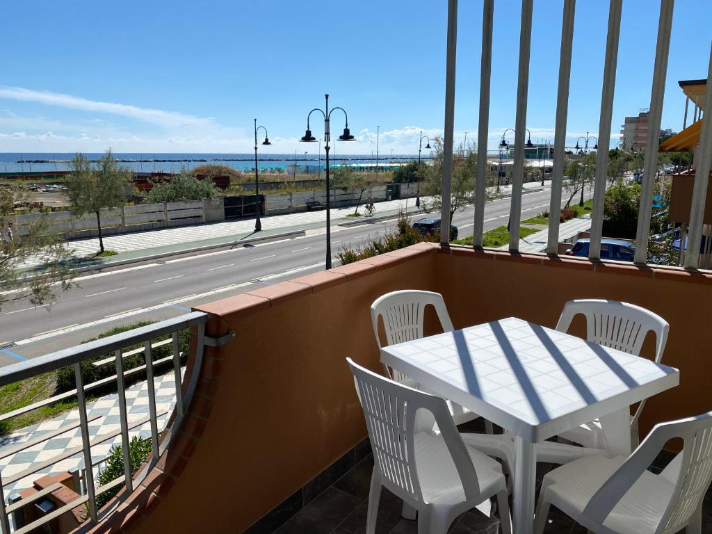 a balcony with a table and chairs and a view of a street at Appartamento Albachiara Vistamare in Cesenatico