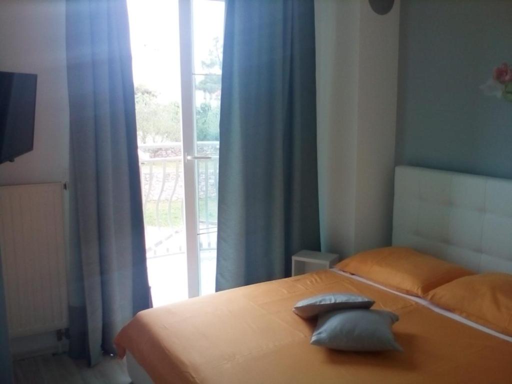 a bedroom with a bed with two pillows on it at Ana Rooms in Krk
