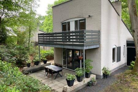 a house with a table and a balcony on a patio at Huize Nuwenspete in Nunspeet