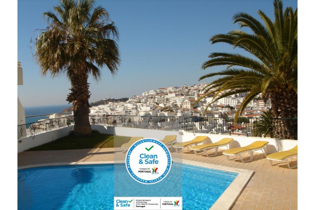 una piscina con sillas y vistas a la ciudad en Silmar, en Albufeira