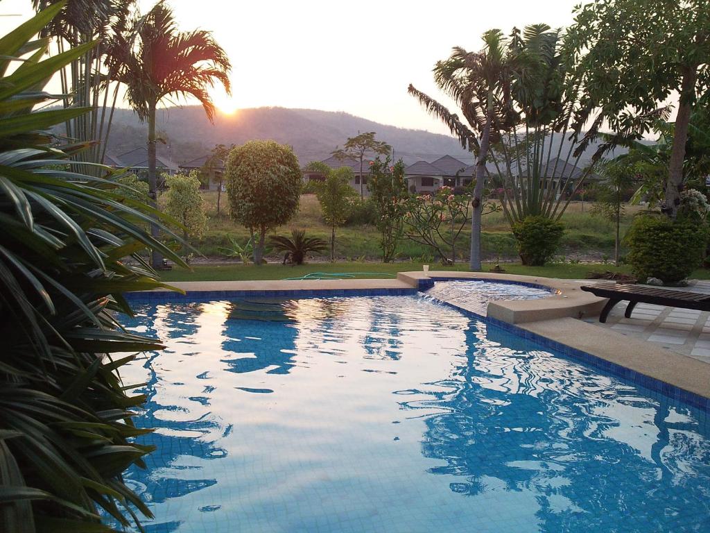 een zwembad met een tafel en palmbomen bij Laguna Villa 2 in Hua Hin