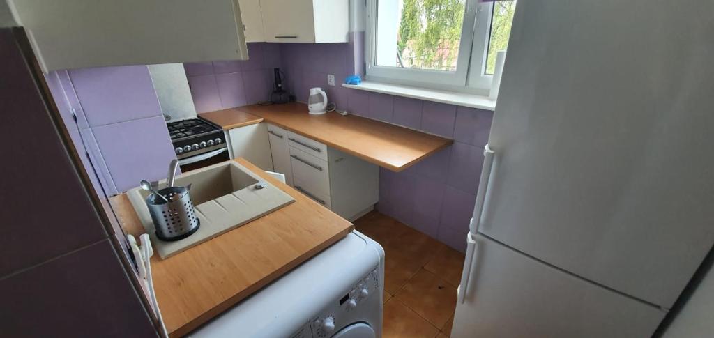 a small kitchen with a sink and a refrigerator at Mieszkanie nad morzem in Gdańsk