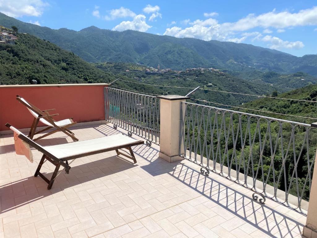 a bench on a balcony with a view of mountains at Le case della Lizza - Casa Rossa in Levanto
